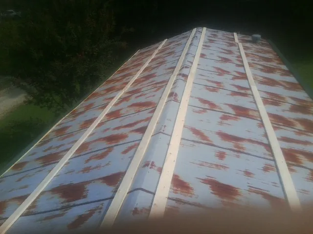 Rusted metal roof panels with new wood purlins before replacement — Storm Damage Roof Repair in Wilmer by Roofing Brothers