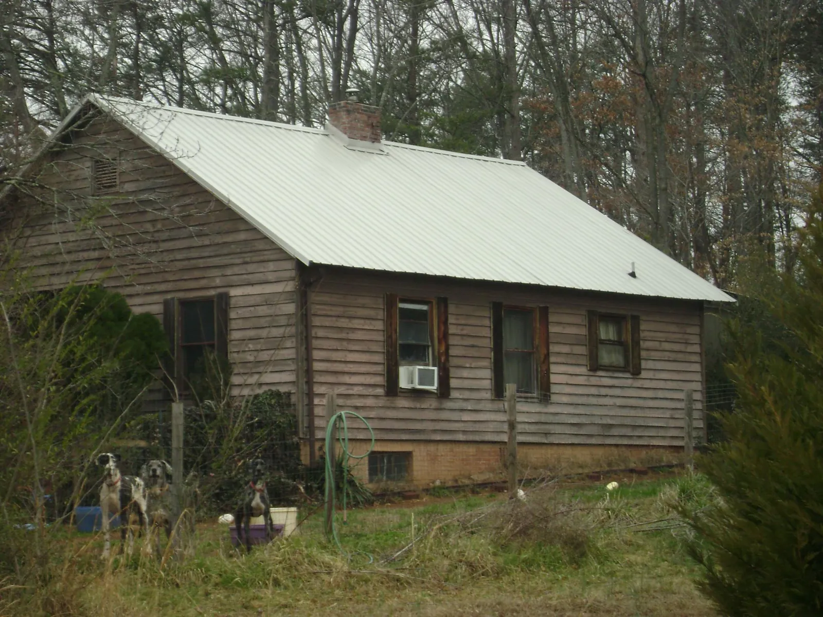 White metal roof on an old wood sided farmhouse, from a Metal Roof Installation job in Wilmer